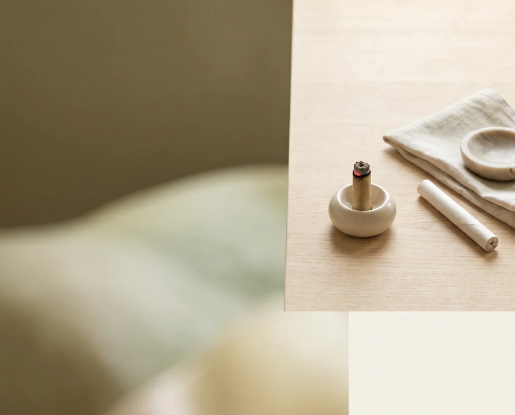A moxa roll in a ceramic holder with natural linen and traditional treatment materials.