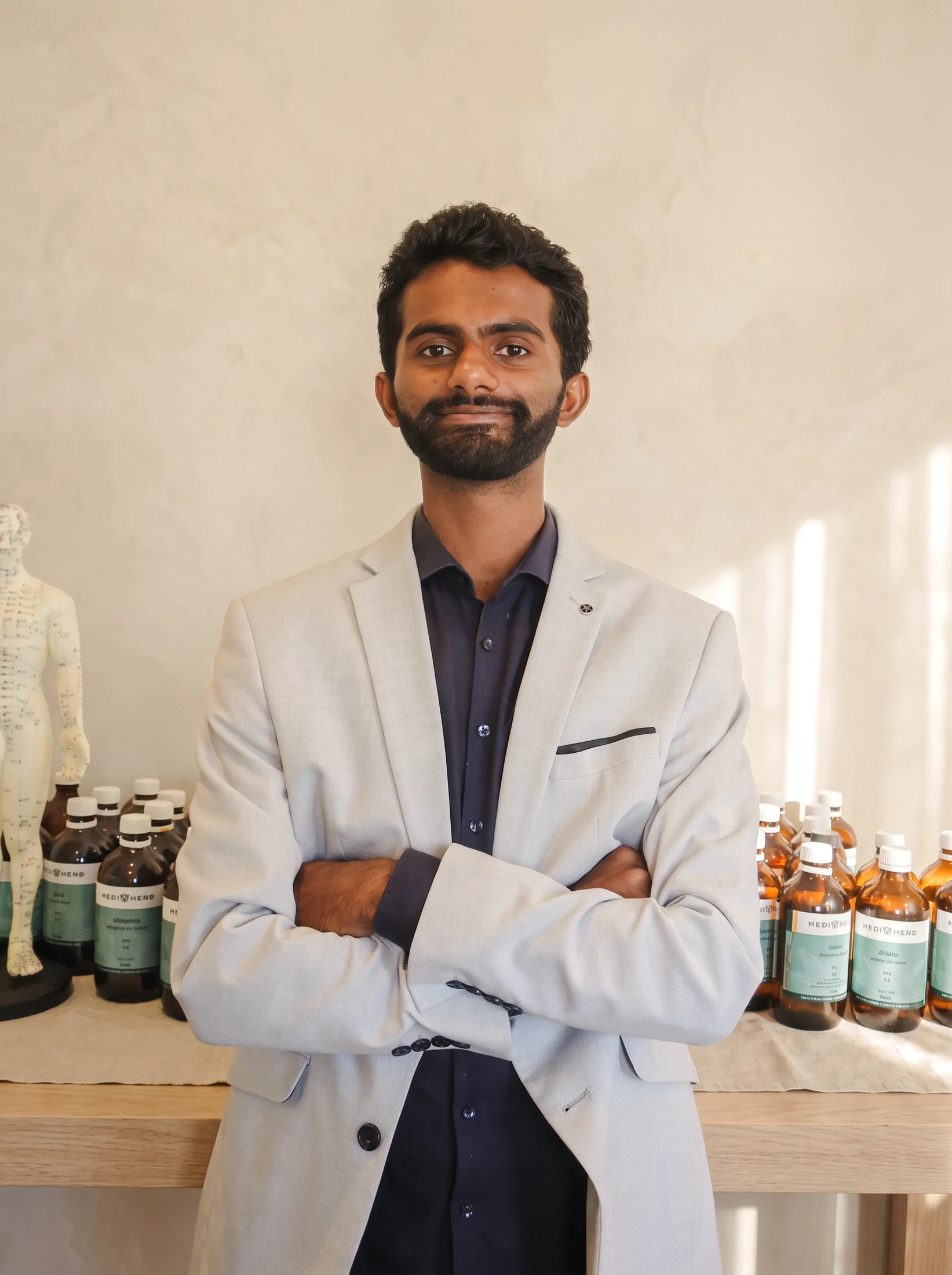 Ahil Ganesan standing in front of the herbal dispensary at his Alexandria clinic