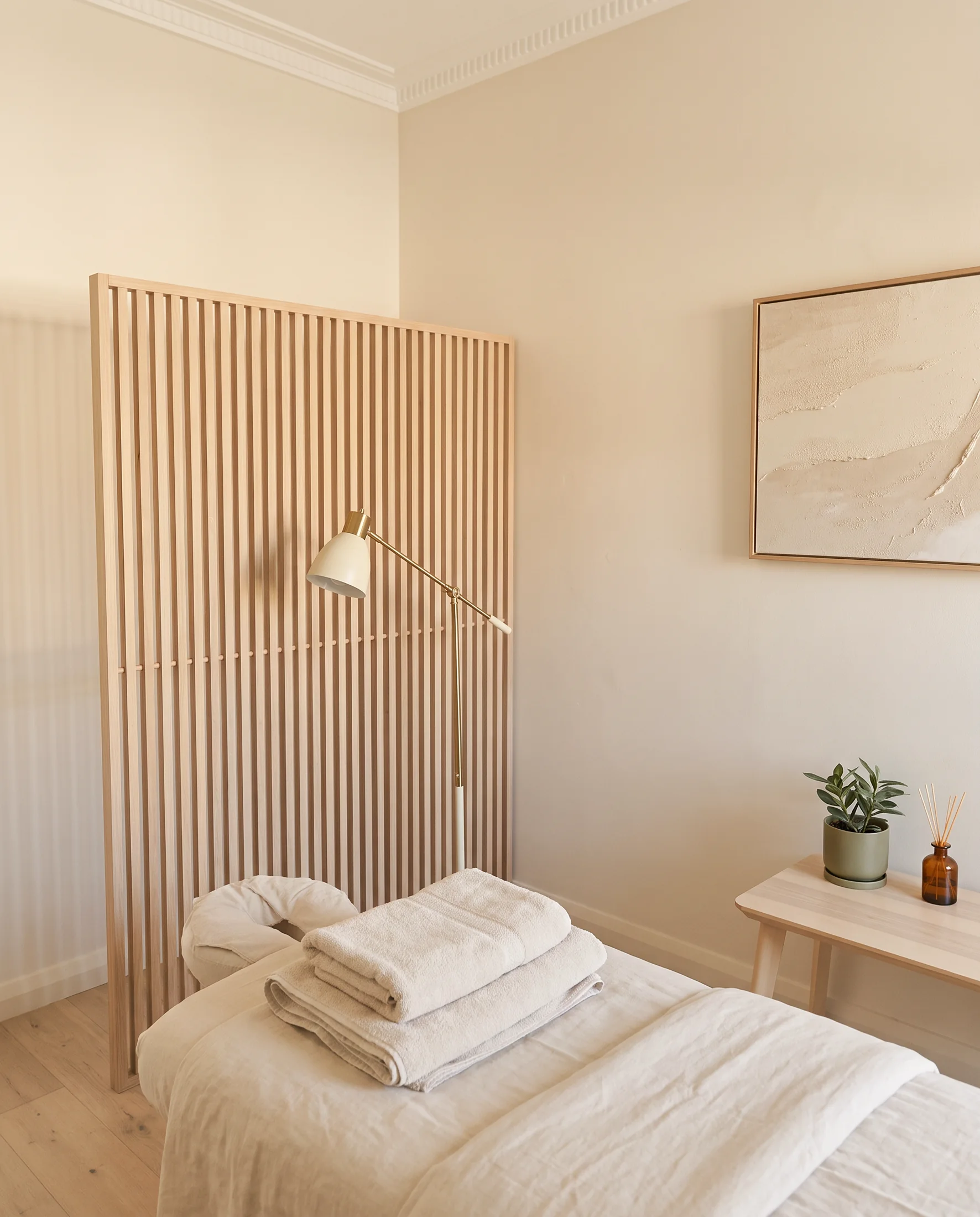 Private treatment room at Project Dao with a timber screen and fresh linen