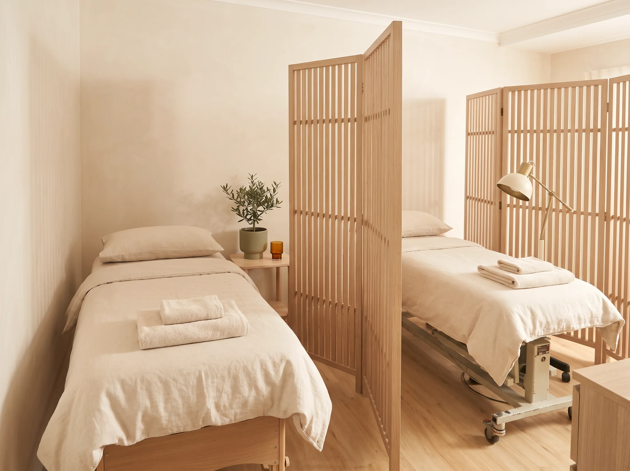 Two treatment tables separated by timber screens at Project Dao